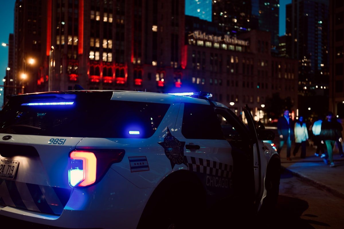 Police car with flashing lights at night representing law enforcement response to cybercrime reports