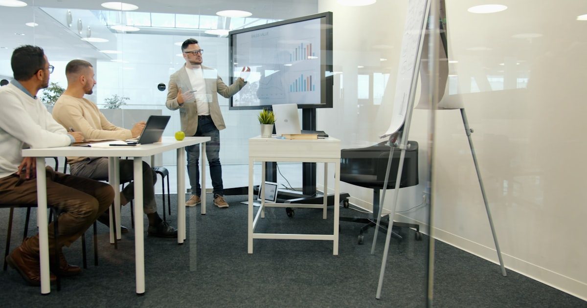 Business team reviewing sales data on a presentation screen