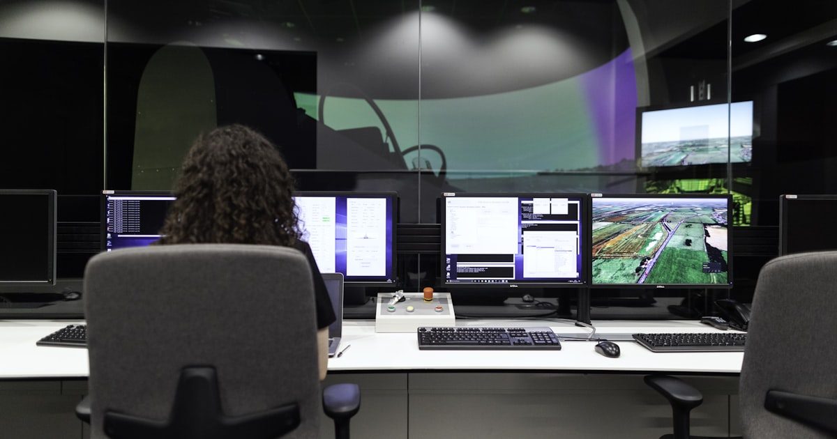 Security engineer monitoring systems on multiple screens in operations center